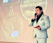 Олегу Бурдиков на фоне изображения Почетного знака 